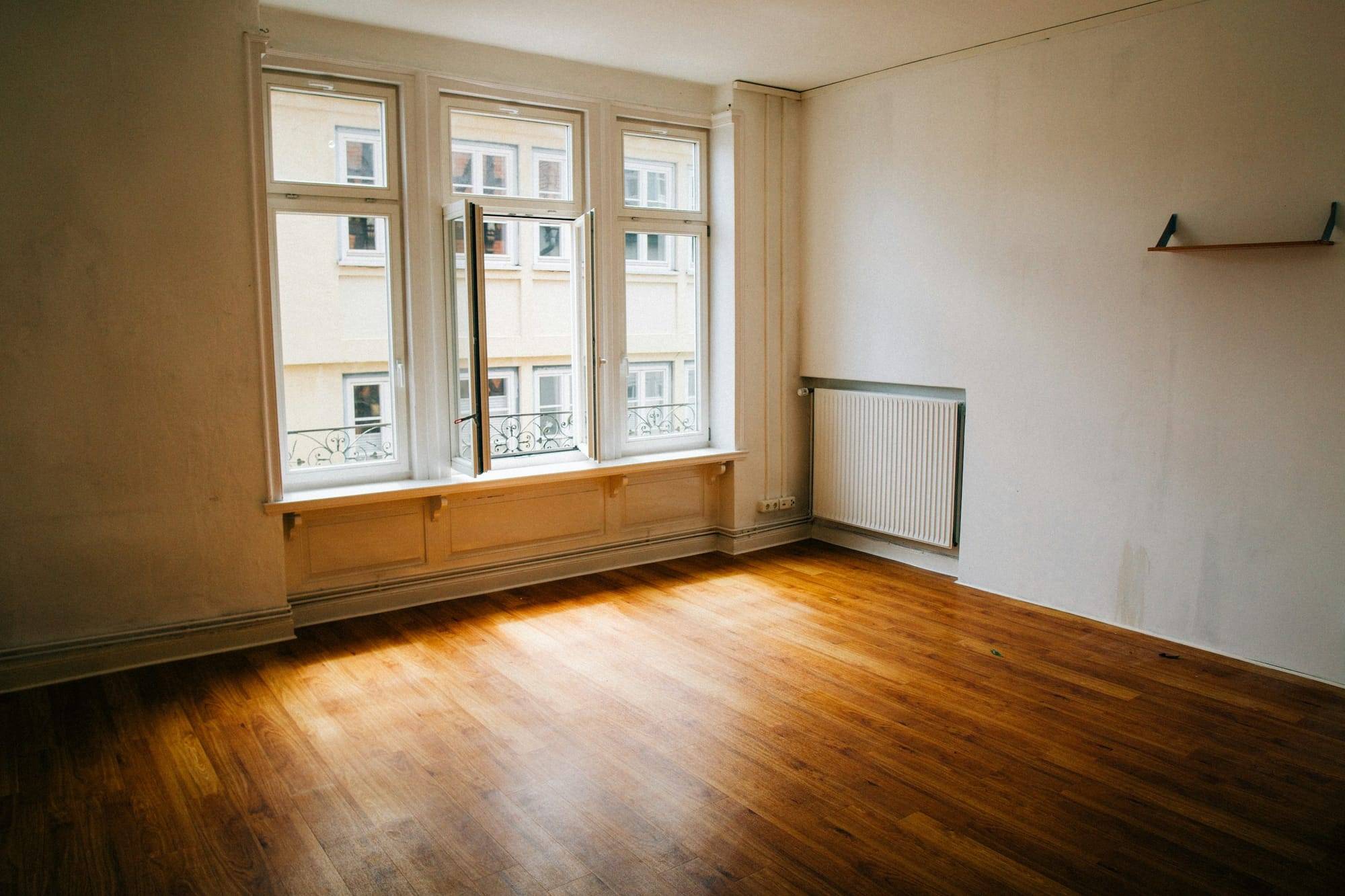 Une pièce vide, le parquet au soleil, les fenêtres ouvertes sur la rue.